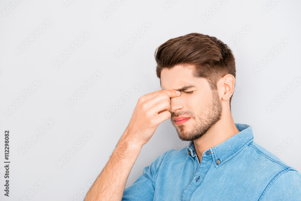 Handsome young overworked man thinking how to solve problems Handsome young overworked man thinking how to solve problems