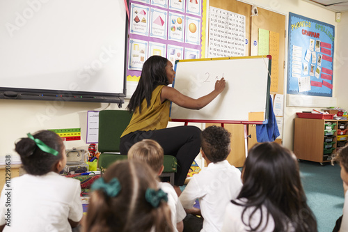 Teacher With Whiteboard In Elementary School Maths Class