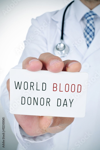 doctor with a signboard with the text blood donor day photo