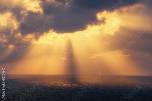 golden sun rays on the sea at sunset photo