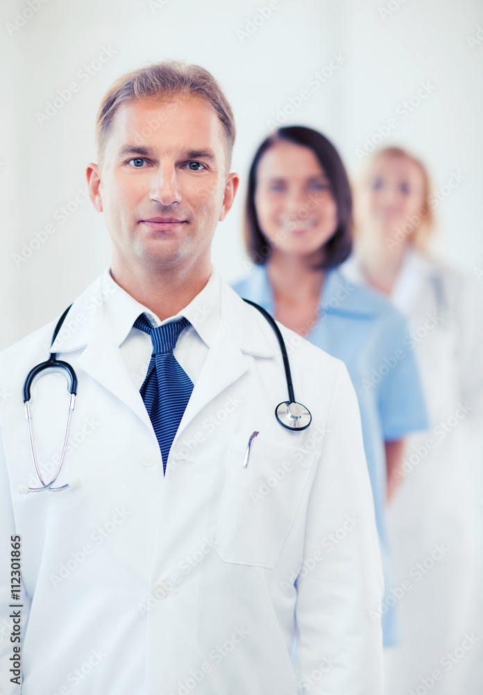 Fototapeta premium doctor with stethoscope and colleagues