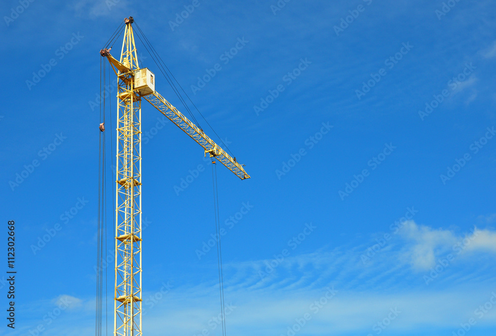 Industrial construction crane with copy space over blue sky background Industrial construction crane with copy space over blue sky background