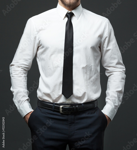 Midsection of young businessman in formal white shirt, black tie photo