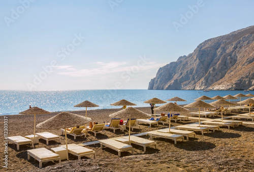 Fototapeta Naklejka Na Ścianę i Meble -  Beach, chairs and umbrellas on volcanic island Santorini, Greece