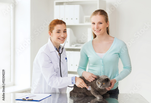 Fototapeta Naklejka Na Ścianę i Meble -  happy woman with cat and doctor at vet clinic