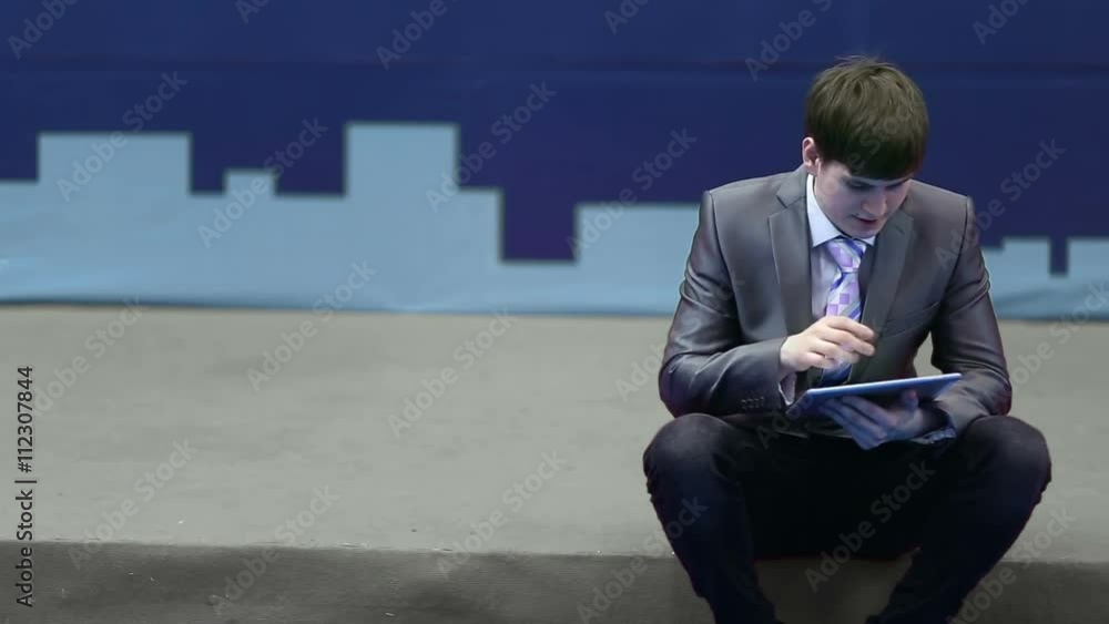 Successful businessman in a suit works with the tablet Successful businessman in a suit works with the tablet