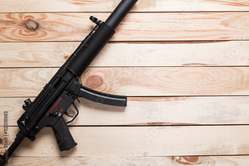 black semi-automatic gun on old wood background.