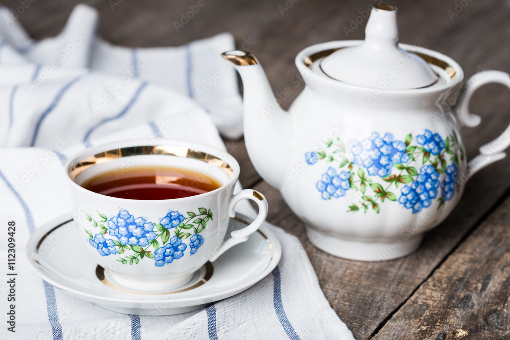 still life with tea cup and tablecloth on wooden table still life with tea cup and tablecloth on wooden table
