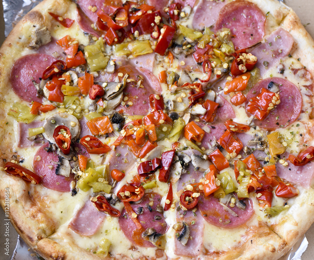 Pepperoni pizza with ham, red peppers and cheese Pepperoni pizza with ham, red peppers and cheese
