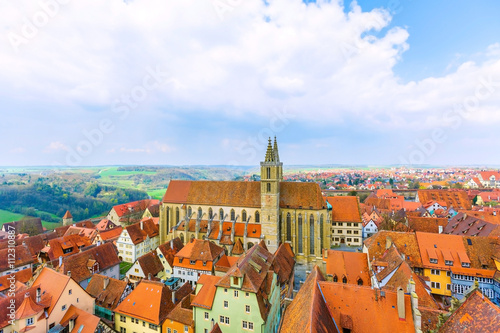 Beautiful aerial view of church St. James, traditional houses and buildings in old medieval town of Rothenburg ob der Tauber with orange roofs, Bavaria romantic road of Germany. 