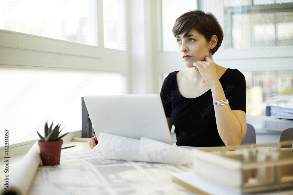 Architect sitting at desk looking through window Architect sitting at desk looking through window