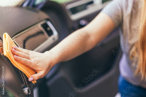 Hand with microfiber cloth cleaning car