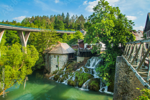      Bridge over Korana river canyon and beautiful village of Rastoke near Slunj in Croatia  old water mills on waterfalls  beautiful countryside landscape 