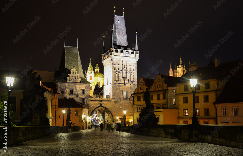 A night view of Charles Bridge with Mala Strana and St. Vitus Cathedral in the background