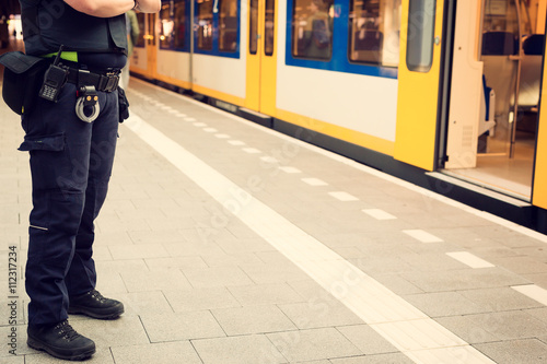 Police officer guarding a train station to prevent terrorist attacks. photo