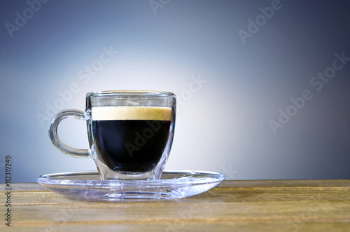 Cup of coffe on the table. Blue and white background