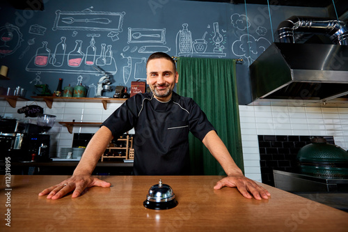 The chef, bartender.  Chef portrait in black uniform behind the photo