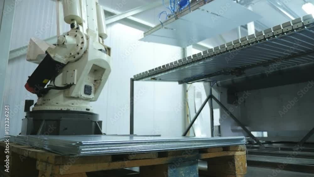 Robotarm picking up peaces of metal in a metal factory Robotarm picking up peaces of metal in a metal factory