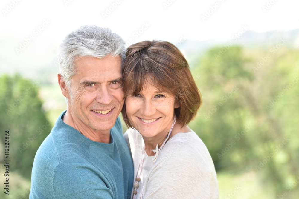 Senior couple embracing each other outside