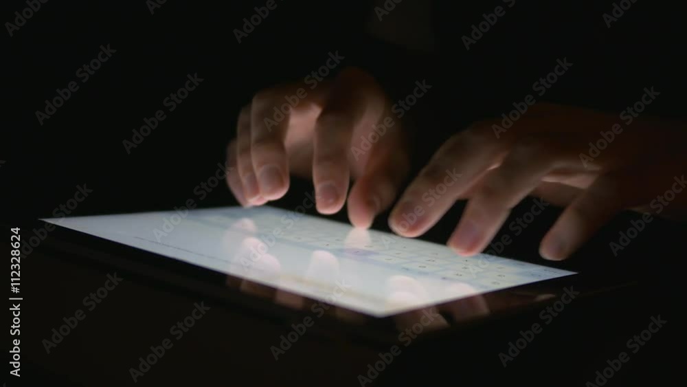 Closeup fingers making gestures on a touchscreen. Dark background. Closeup fingers making gestures on a touchscreen. Dark background.