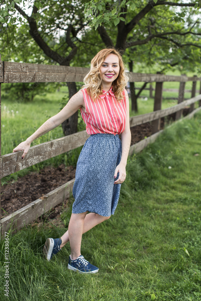 young happy girl standing at wooden fence in countryside young happy girl standing at wooden fence in countryside