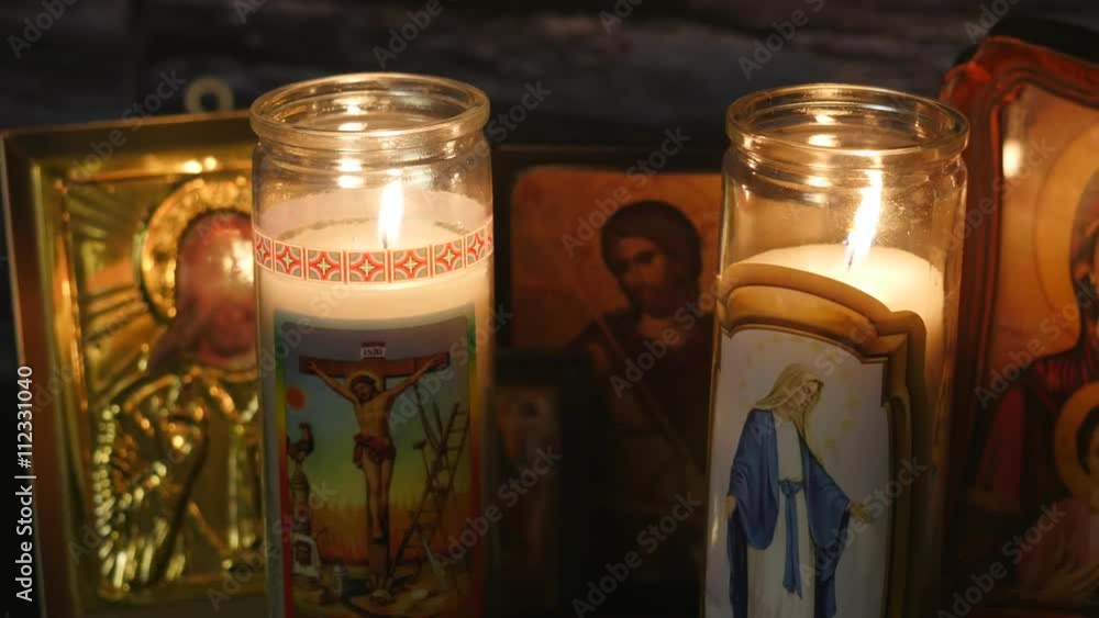 Religious candle burning with icones of jesus and mother Mary in the background. Filmed in 4K. Religious candle burning with icones of jesus and mother Mary in the background. Filmed in 4K.