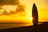 Surfboard on the beach at sunset


