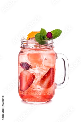 Lemonade in transparent mug with strawberry, decorated with roses and orange peel