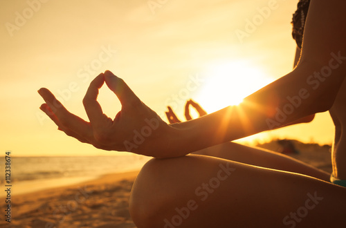 Woman doing yoga on the beach. Relax the mind. photo