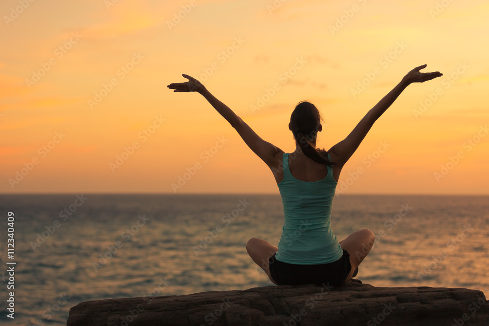 Happy woman meditating in a beautiful setting.

