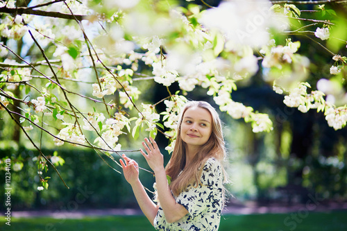 Beautiful young woman in blooming spring park