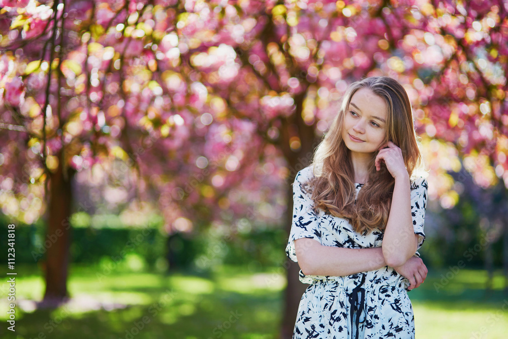 Beautiful young woman in blooming spring park