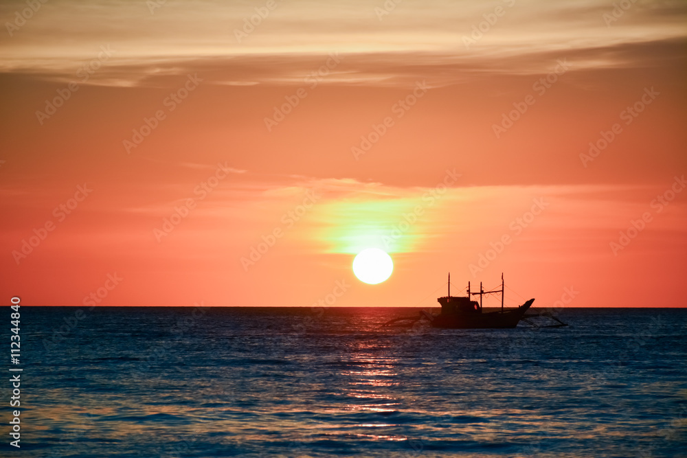 Sunset in Boracay, Philippines with a boat in the foreground