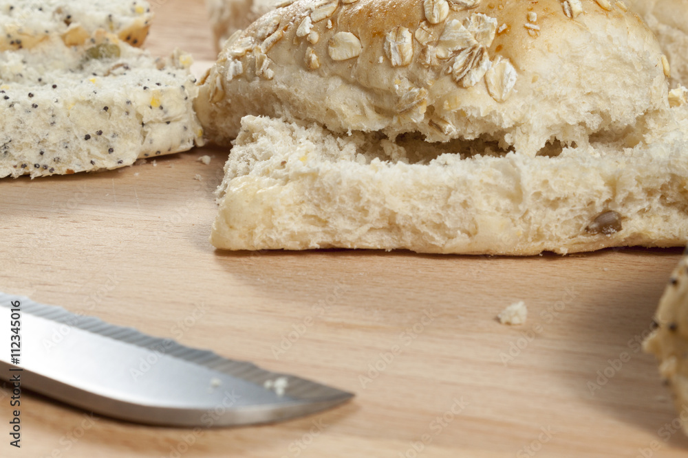 Oat flake bread rolls laying on a wooden breadboard Oat flake bread rolls laying on a wooden breadboard