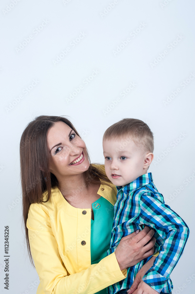 Boy in shirt sitting with mom on light background Boy in shirt sitting with mom on light background