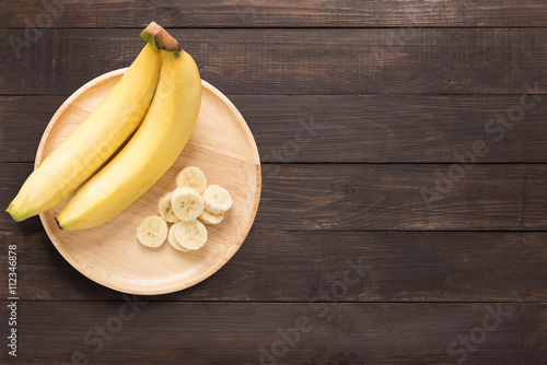 Bananas in a wooden dish on a wooden background. space for text