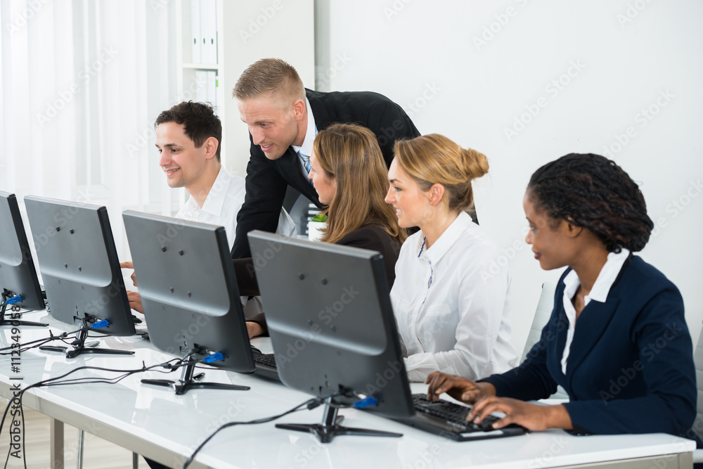 Businessman Helping His Colleagues In The Office Businessman Helping His Colleagues In The Office