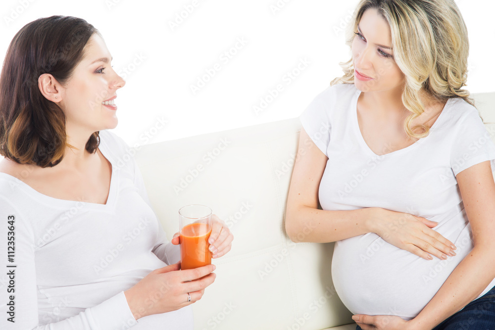 Two expectant mothers staying healthy with fruits and fresh juic Two expectant mothers staying healthy with fruits and fresh juic