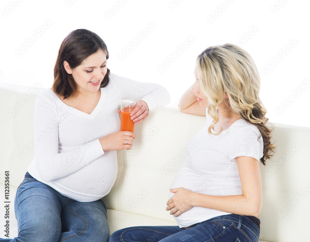 Two expectant mothers staying healthy with fruits and fresh juic