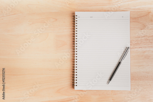 a pen and blank paper of open book