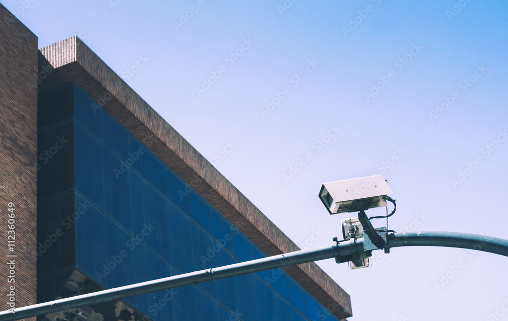 Security camera on blue sky background and glass building Security camera on blue sky background and glass building