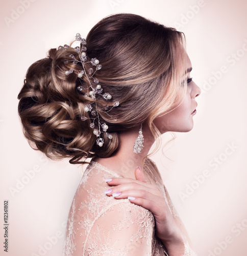 Beautiful bride with fashion wedding hairstyle - on beige background.Closeup portrait of young gorgeous bride. Wedding. Studio shot.