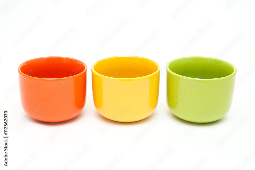A set of three standing in a number of ceramic cups: orange, yel A set of three standing in a number of ceramic cups: orange, yel