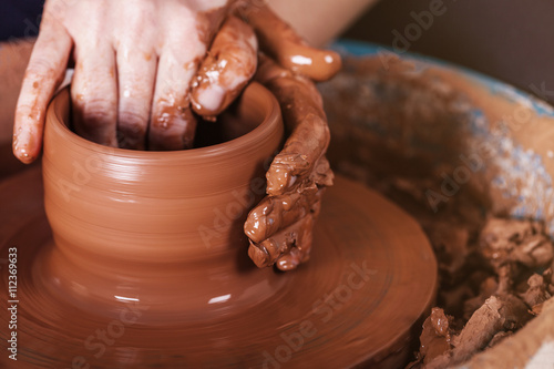 Men's hands. Potter at work. Creating dishes. Potter's wheel. Di