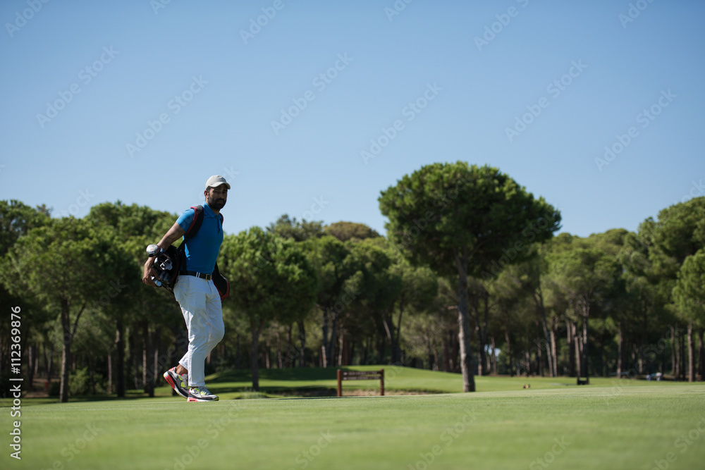 Obraz premium golf player walking and carrying bag