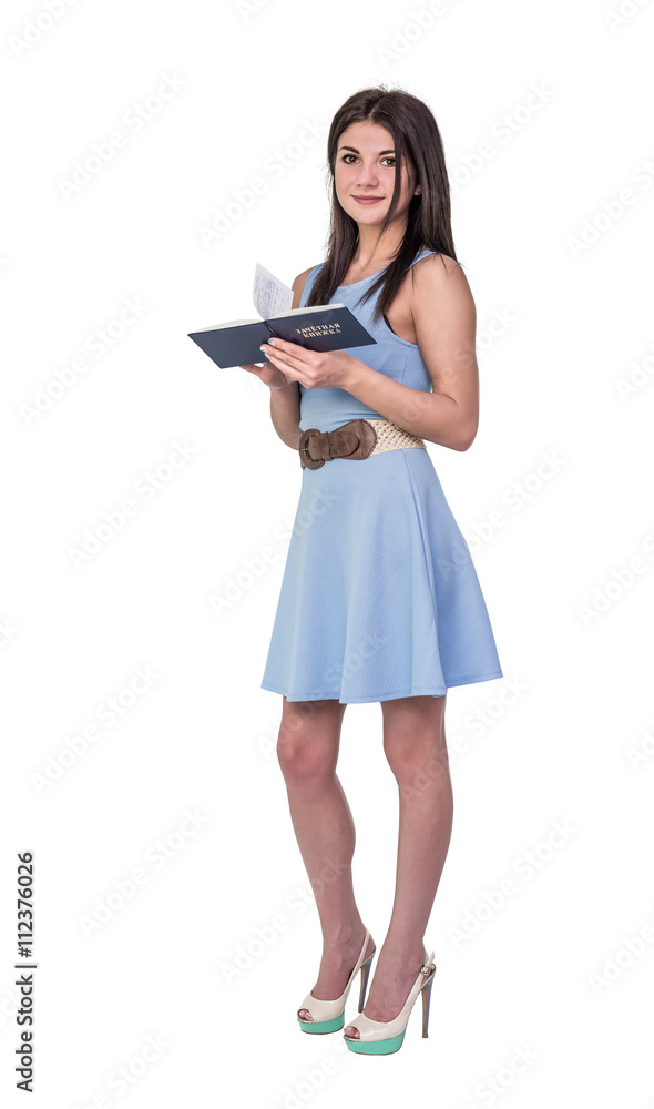 A girl student in the blue dress hold a record book on an isolated white background. On the cover is written in Russian: test book. A girl student in the blue dress hold a record book on an isolated white background. On the cover is written in Russian: test book.