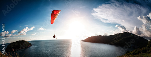 Paraglider flying over the water