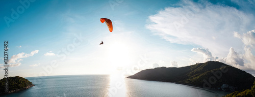 Paraglider flying over the water
