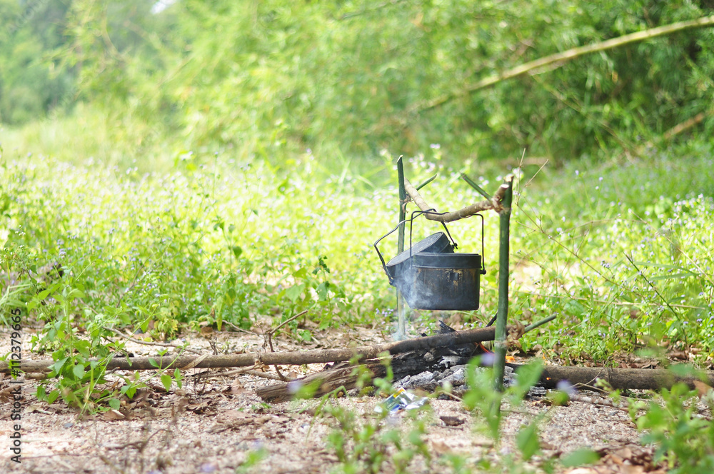 Cooking pot in campfire, Camping in forest Cooking pot in campfire, Camping in forest