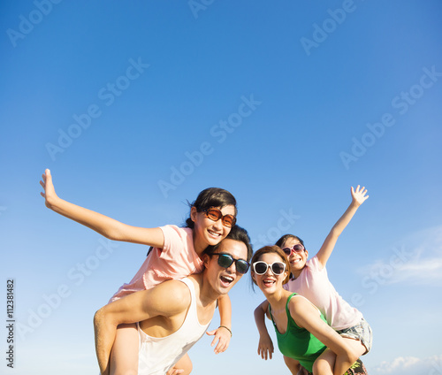 Canvas Print happy family having fun outdoors against blue sky background